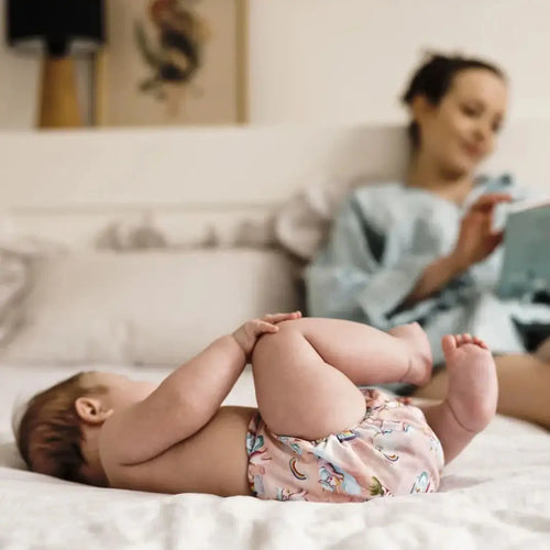 Neonata con mutandine spannolinamento lavabili motivo unicorni — mamma serena sullo sfondo